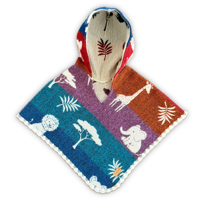 A hooded knit poncho with a colorful safari-themed print, featuring white animal silhouettes including a giraffe, elephant, lion, and acacia trees on blue, purple, and orange panels, with a beige hood lining.